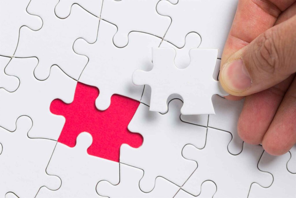 hand putting the last piece of white puzzle for bu       utc x